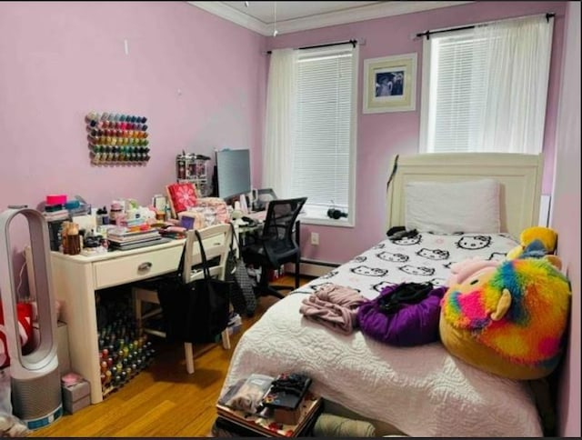 bedroom featuring crown molding, a baseboard radiator, and light hardwood / wood-style flooring