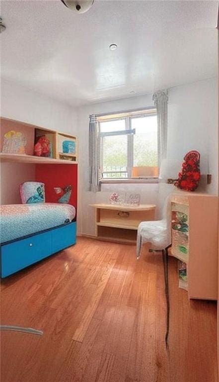 bedroom with hardwood / wood-style floors and a textured ceiling