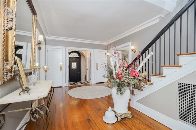 entryway with stairway, ornamental molding, baseboards, and hardwood / wood-style flooring