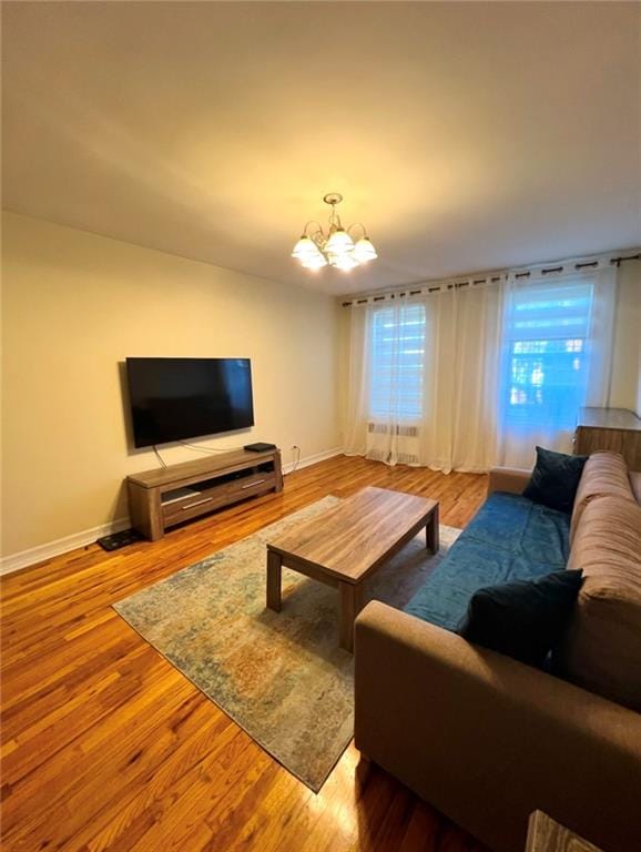 living room featuring radiator, hardwood / wood-style flooring, and a chandelier