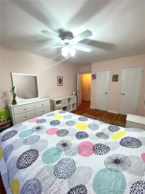 bedroom featuring ceiling fan and dark wood-style flooring