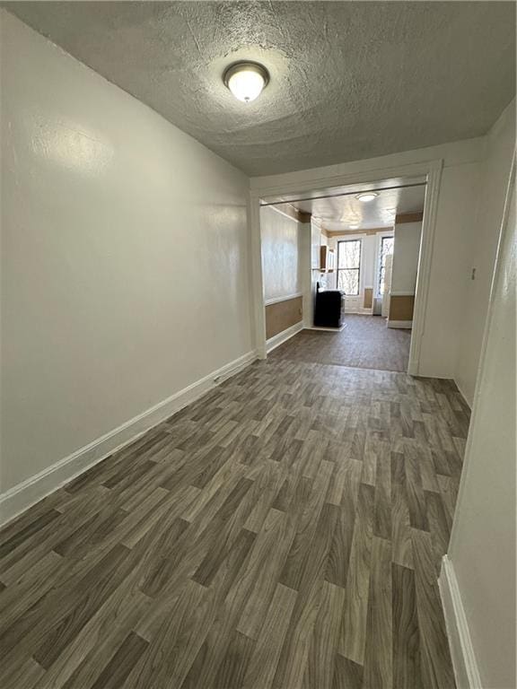 unfurnished living room featuring dark hardwood / wood-style flooring and a textured ceiling