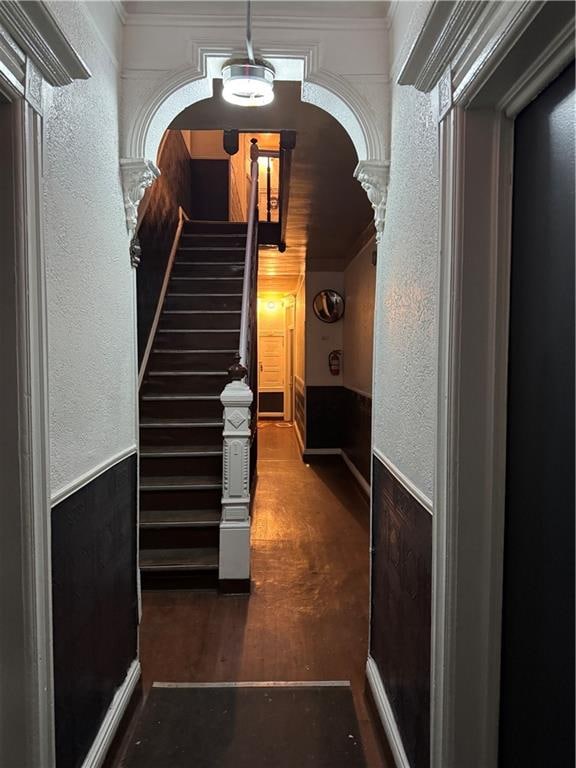 corridor featuring dark hardwood / wood-style flooring, ornamental molding, and ornate columns