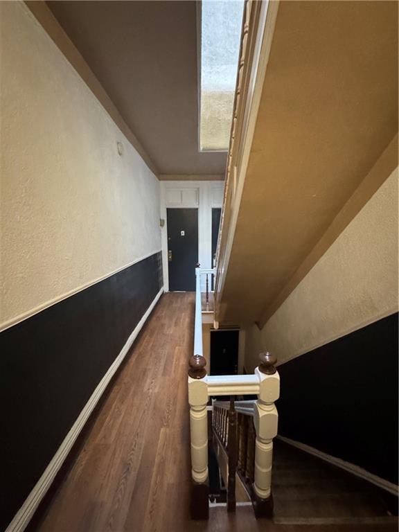 hallway featuring lofted ceiling and dark hardwood / wood-style floors