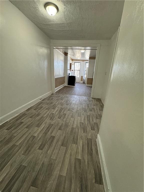 spare room with dark wood-type flooring and a textured ceiling