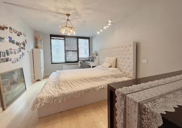 bedroom featuring a chandelier and light hardwood / wood-style flooring