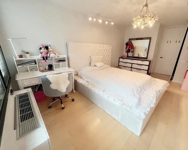 bedroom with a notable chandelier and light hardwood / wood-style floors