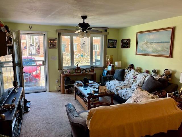 carpeted living room featuring ceiling fan