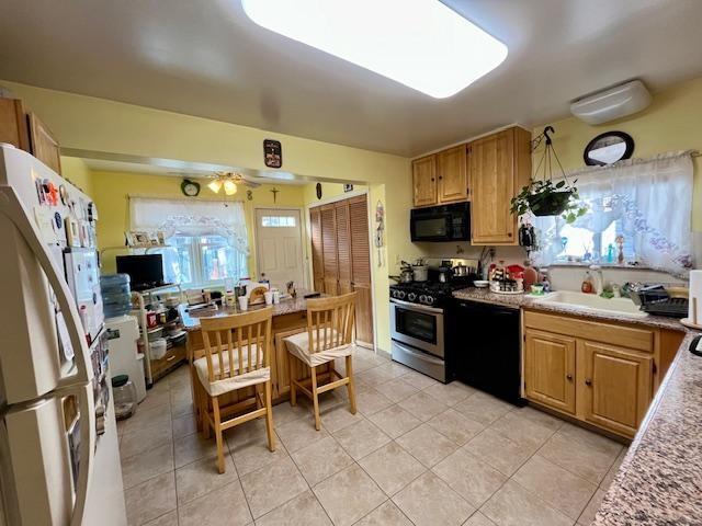 kitchen with sink, light tile patterned floors, ceiling fan, and black appliances