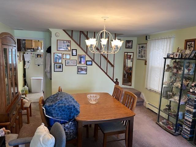 dining room featuring a notable chandelier and carpet floors