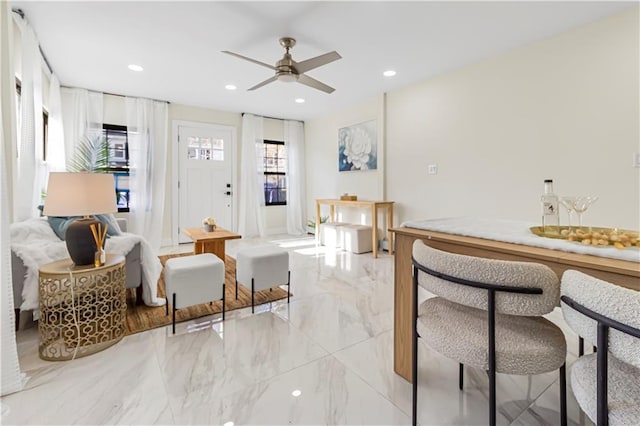 living room with ceiling fan and indoor bar