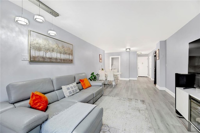 living area with light wood-type flooring and baseboards