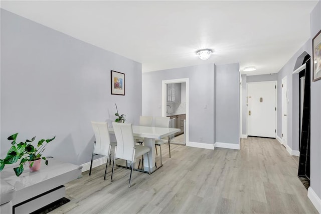 dining area featuring light wood-style floors and baseboards