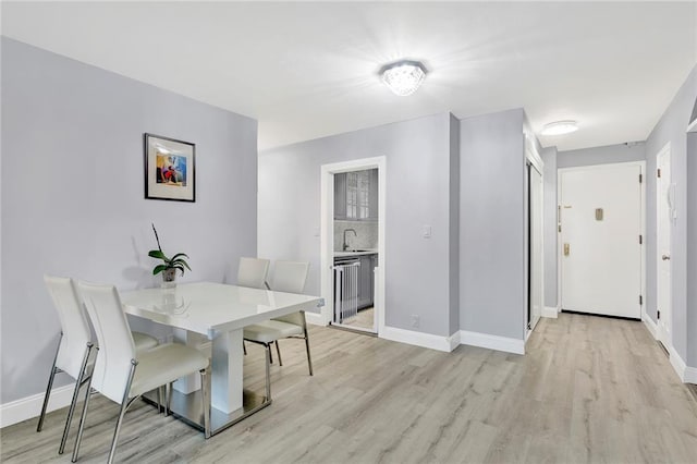 dining room with light wood-type flooring and baseboards