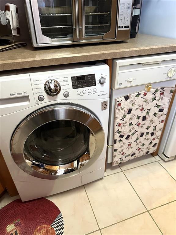 washroom featuring light tile patterned flooring and washer / dryer