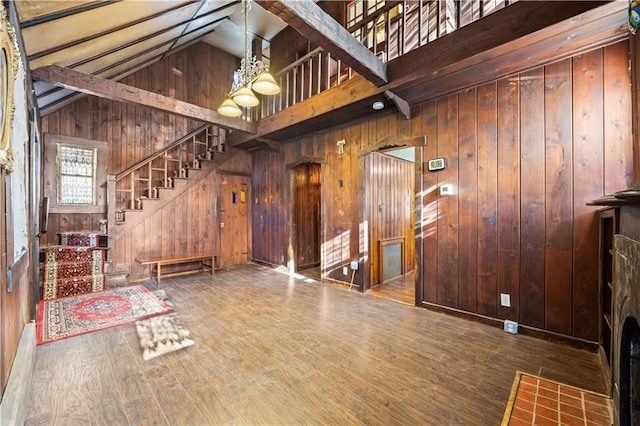 interior space with hardwood / wood-style flooring, high vaulted ceiling, and wood walls