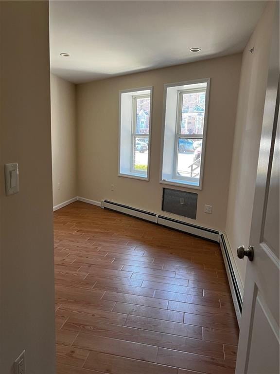 spare room with hardwood / wood-style flooring and a baseboard radiator