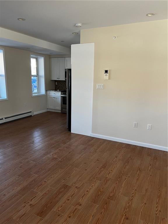 interior space with dark wood-type flooring and a baseboard radiator