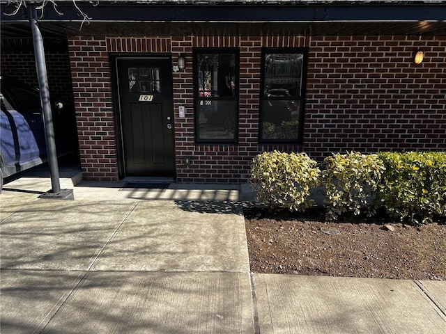 view of exterior entry featuring brick siding