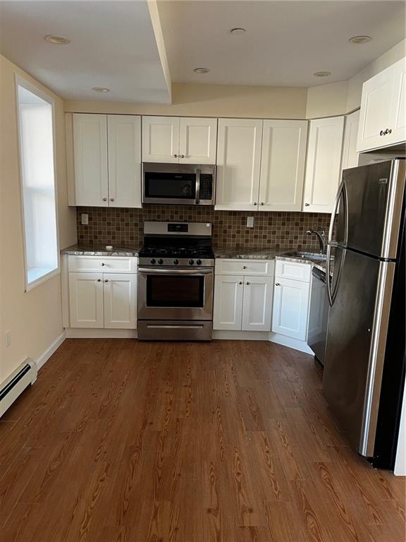 kitchen featuring white cabinetry, decorative backsplash, dark hardwood / wood-style flooring, and appliances with stainless steel finishes