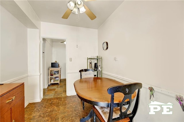 dining room with stone finish floor and ceiling fan