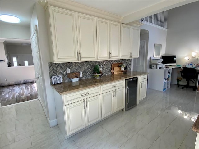 kitchen featuring decorative backsplash, wine cooler, marble finish floor, baseboards, and stone countertops