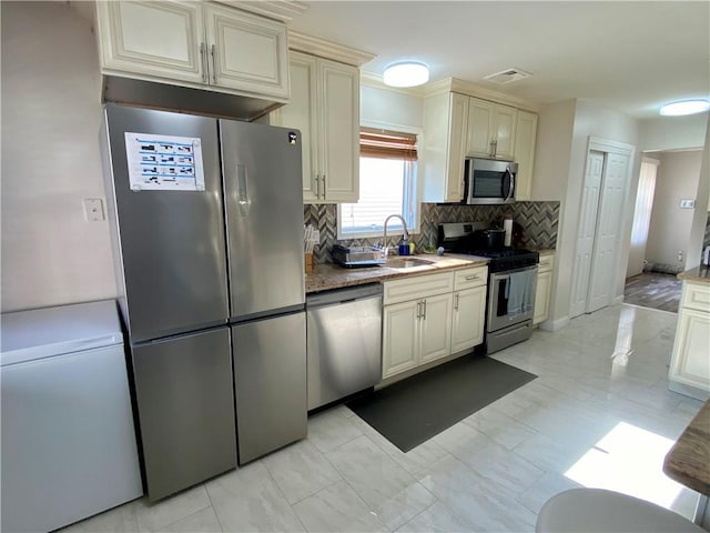 43 Lerer Ln, Staten Island, NY 10307 - kitchen featuring stainless steel appliances, cream cabinets, tasteful backsplash, and light stone countertops