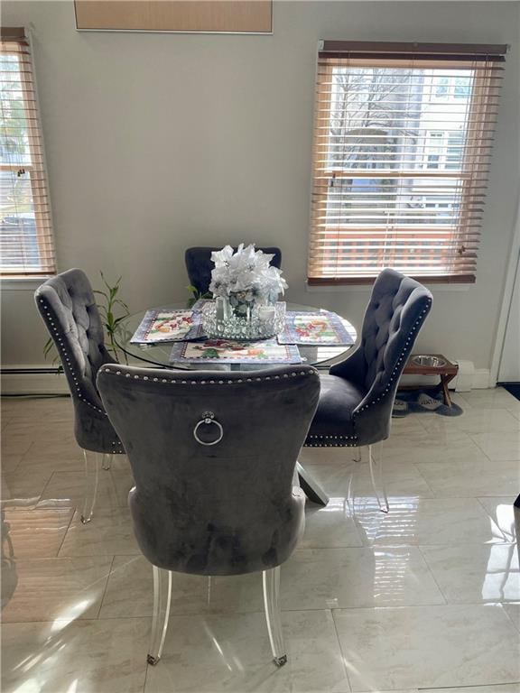 dining area with baseboards, a wealth of natural light, and a baseboard radiator
