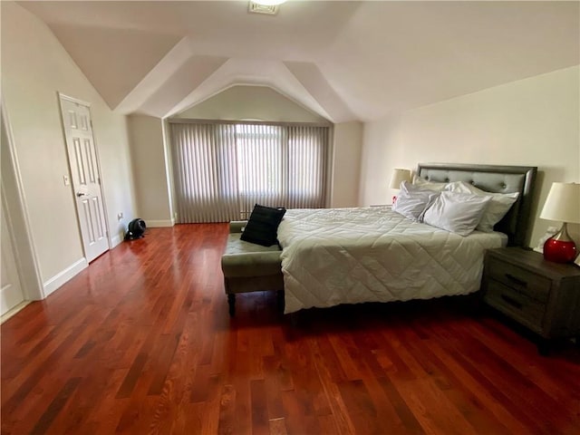 bedroom with lofted ceiling, wood finished floors, and baseboards
