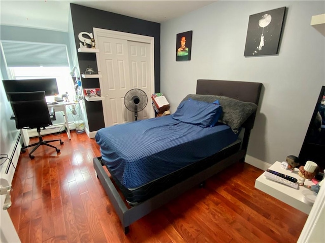 bedroom with baseboards, hardwood / wood-style flooring, and a closet
