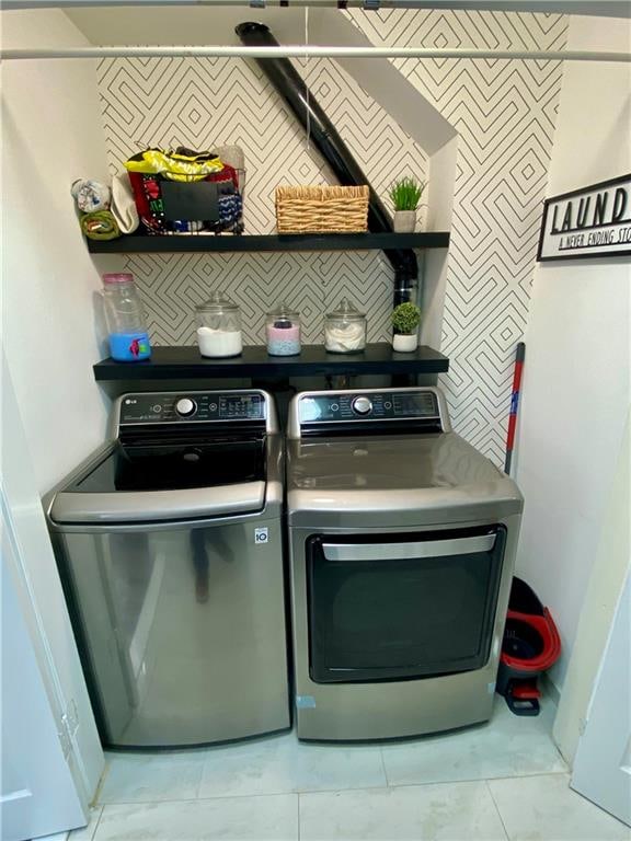 washroom with washing machine and dryer and wallpapered walls