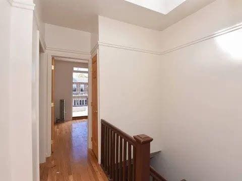 hallway featuring hardwood / wood-style flooring and a skylight