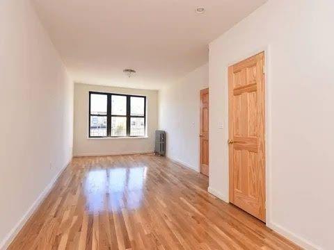 empty room with radiator heating unit and light wood-type flooring