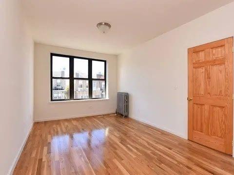 empty room with radiator and wood-type flooring