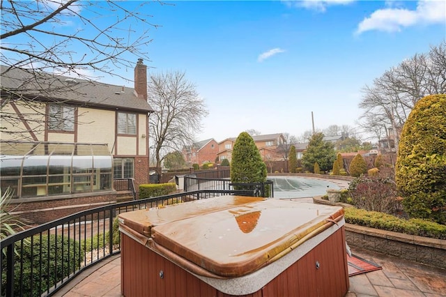 deck with a hot tub and a residential view