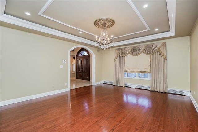 unfurnished room featuring arched walkways, a chandelier, wood finished floors, crown molding, and a raised ceiling
