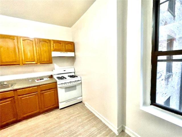 kitchen featuring sink, white gas range, and light hardwood / wood-style floors