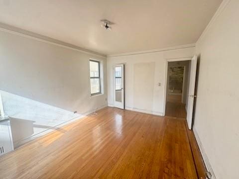 empty room featuring hardwood / wood-style floors and crown molding