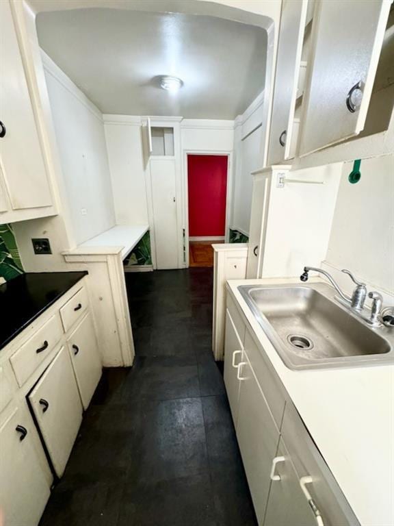 kitchen featuring white cabinetry and sink