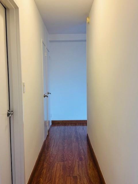 hallway featuring wood finished floors and baseboards