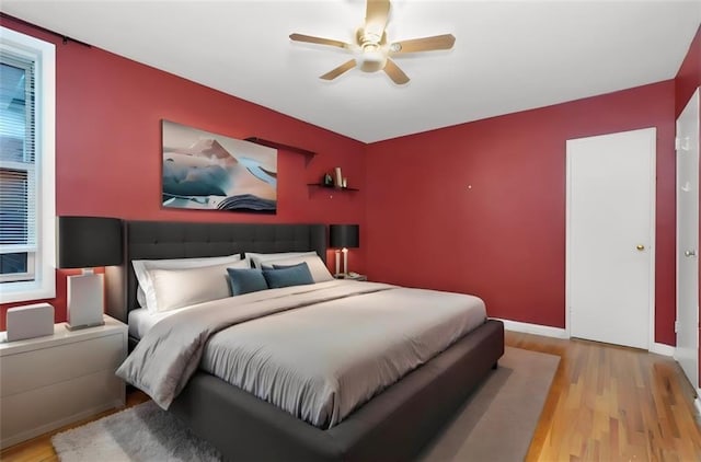 bedroom with light hardwood / wood-style floors and ceiling fan