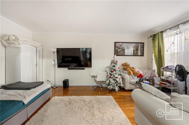 living room with baseboards, ornamental molding, and light wood-style floors