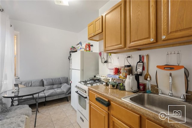 kitchen featuring white appliances, sink, and light tile patterned floors