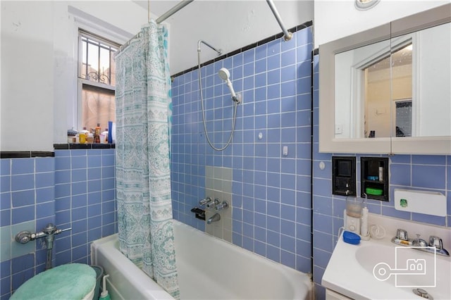 full bathroom featuring vanity, toilet, shower / bath combo with shower curtain, and tile walls