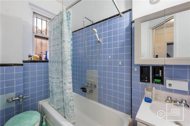 bathroom featuring tile walls, shower / tub combo, and vanity