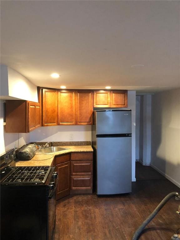 kitchen with dark wood-type flooring, stainless steel fridge, sink, and black range with gas cooktop