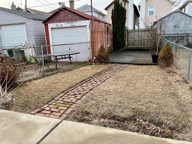 view of yard featuring fence and an outbuilding