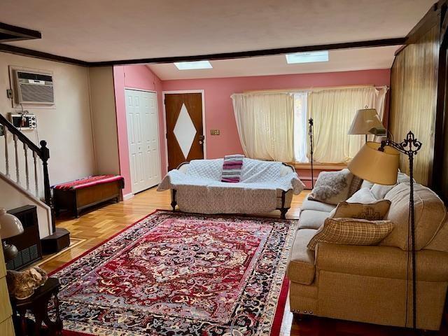 living room featuring stairs, vaulted ceiling, and a wall mounted AC