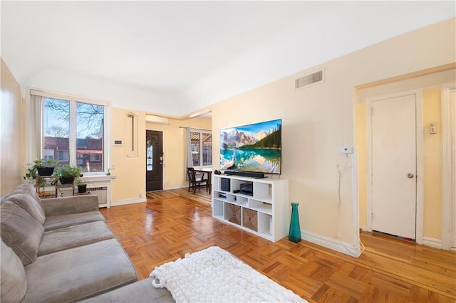 living area featuring baseboards, visible vents, and radiator