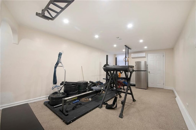 exercise room with baseboards, light colored carpet, an AC wall unit, and recessed lighting